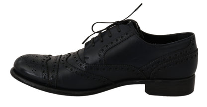 Sort snøresko set fra siden med dekorative perforeringer og brogue-detaljer.