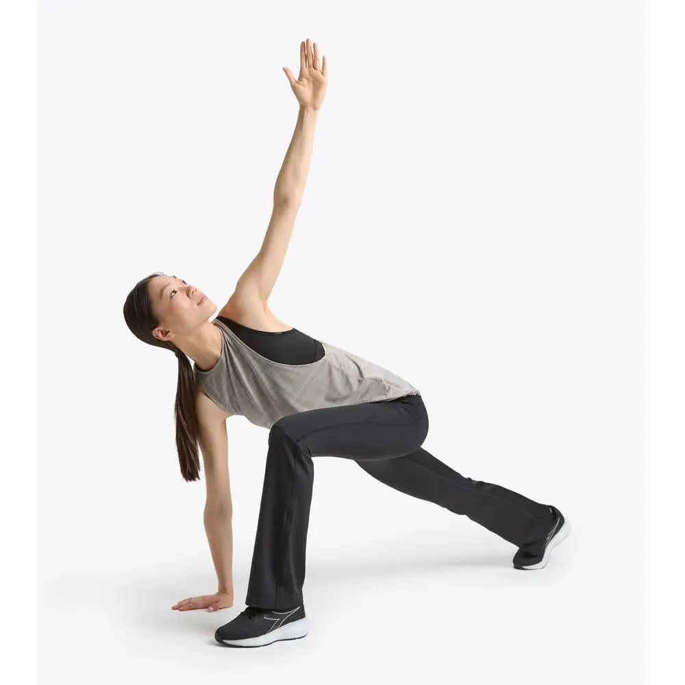 Kvinde i Diadora grå sort tank top udfører yoga i originale athletic pants