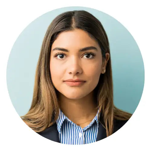 En kvinde med langt brunt hår iført en blå og hvid stribet krave-shirt.