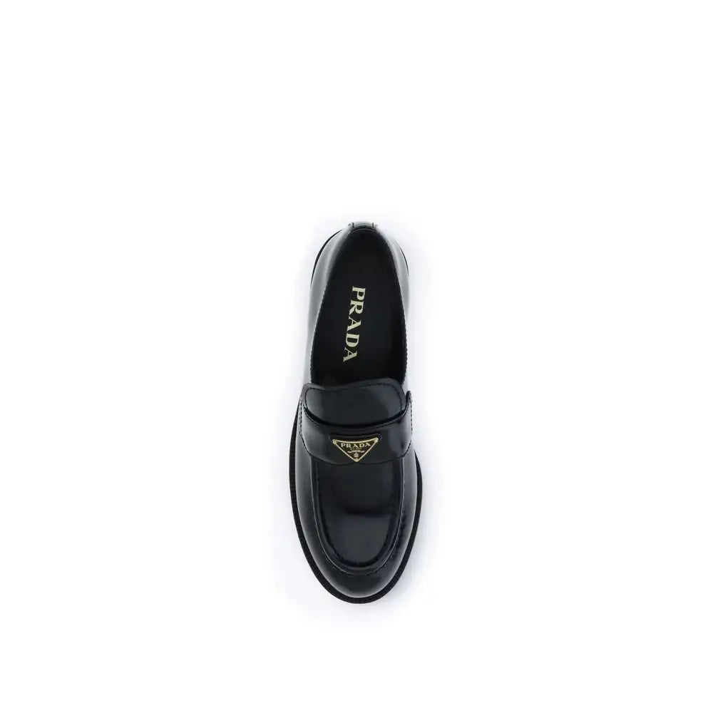 Prada black calf leather Bos Taurus slip-on loafers with glossy finish and gold-tone triangular logo