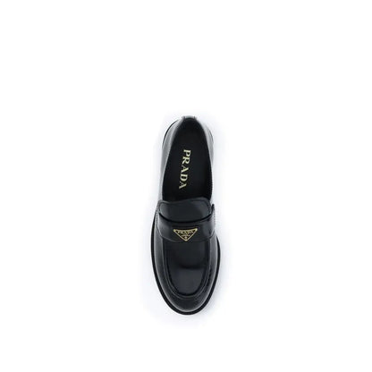 Prada black calf leather Bos Taurus slip-on loafers with glossy finish and gold-tone triangular logo