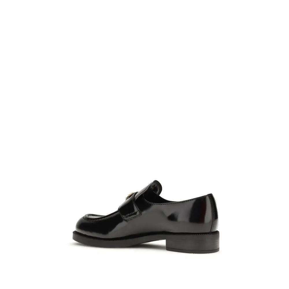 Prada black calf leather Bos Taurus slip-on loafers with glossy finish and metallic buckle
